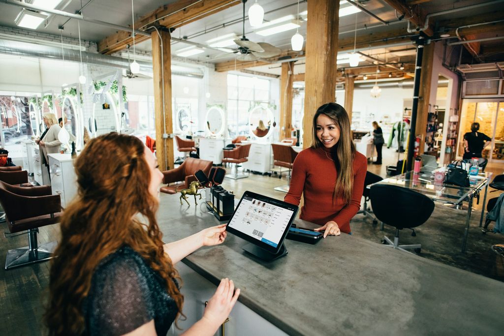 Una persona paga con un tablet POS al banco di un salone